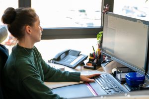 Frau sitzt am PC und schaut in Monitor